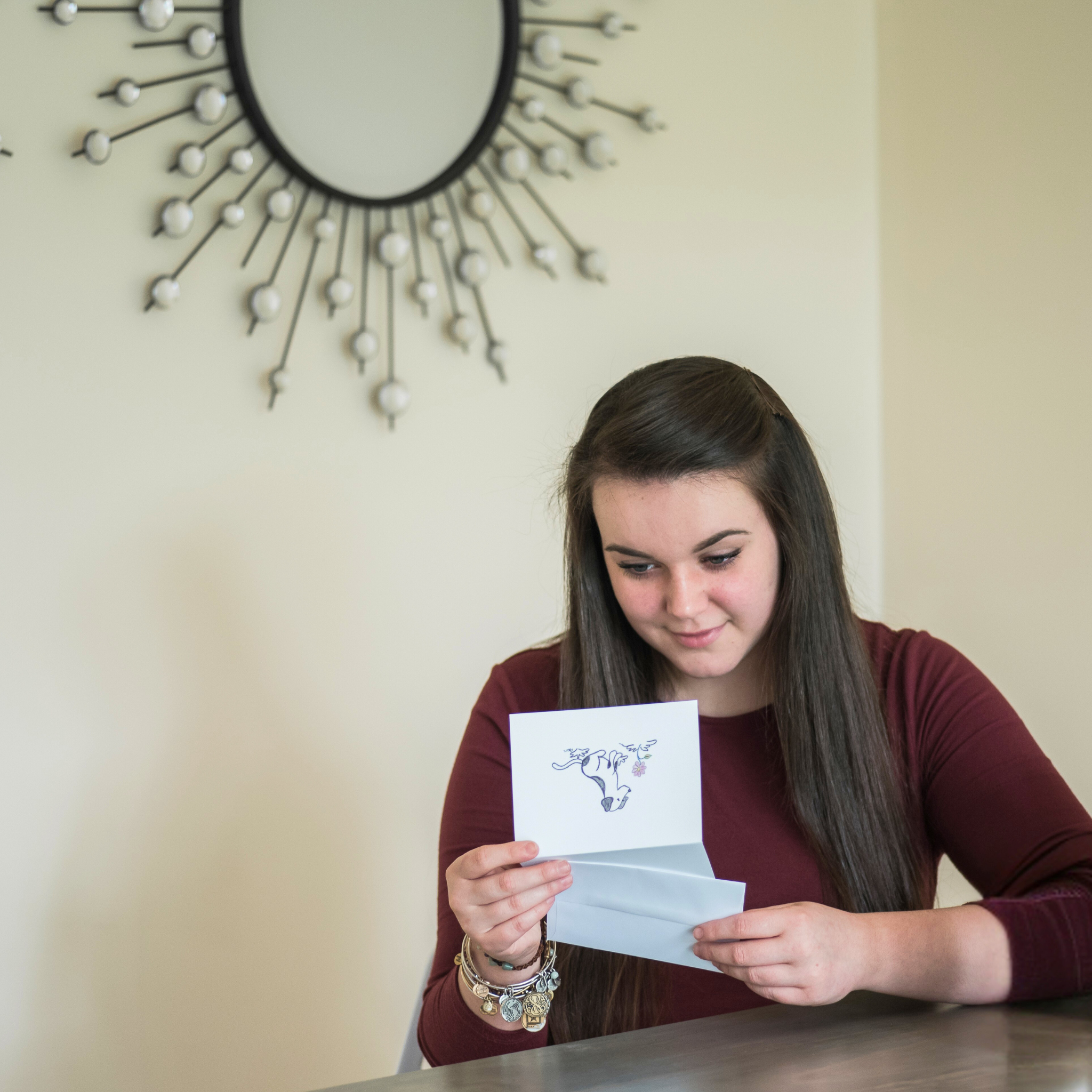 Woman reading a heartfelt sympathy card in honor of her beloved pet — a touching scene featured in sympathy gifts for loss of pet and ideas on what to buy someone when their pet passes away.