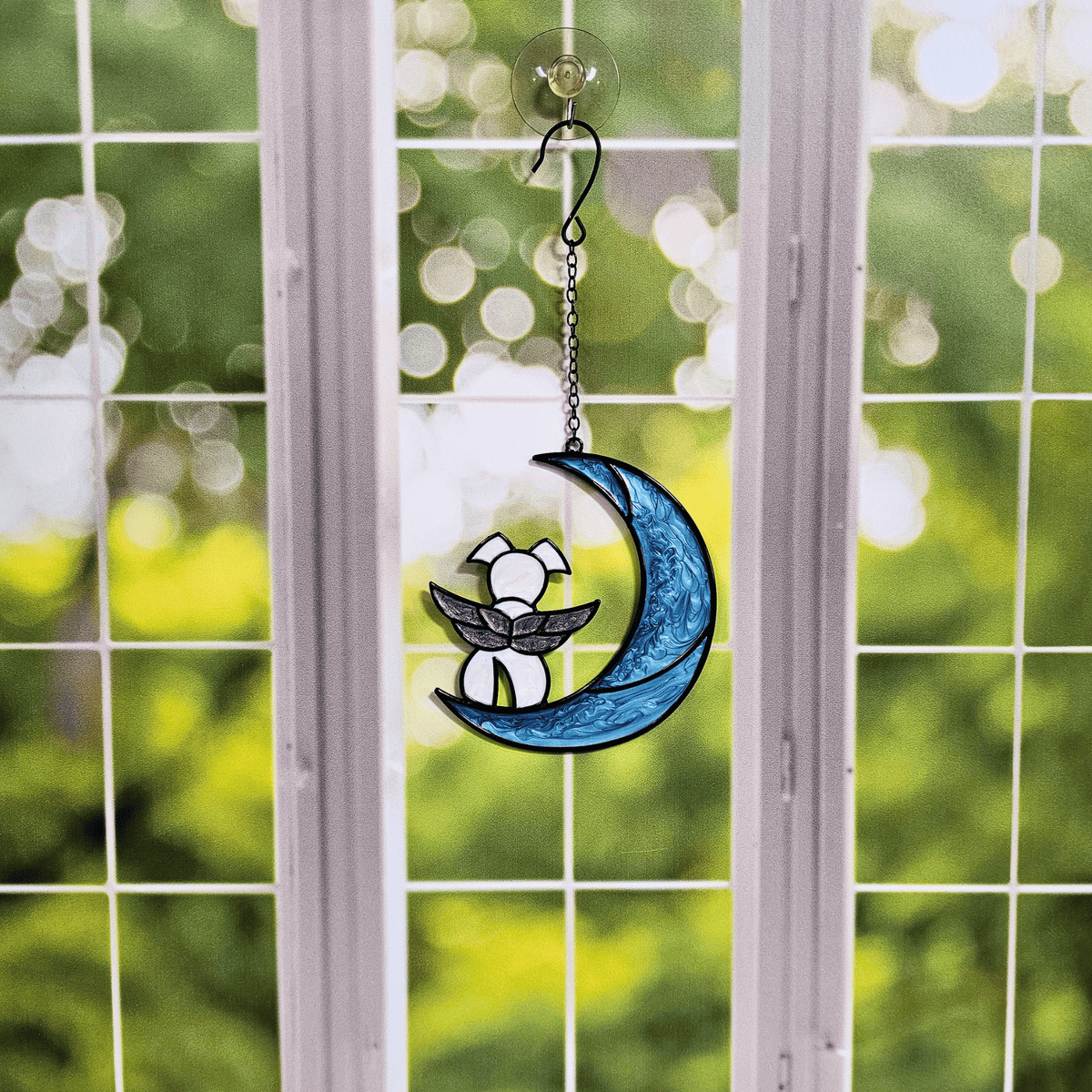 Dog on Moon with Angel Wings Memorial Suncatcher for Pet Loss hanging in a window.