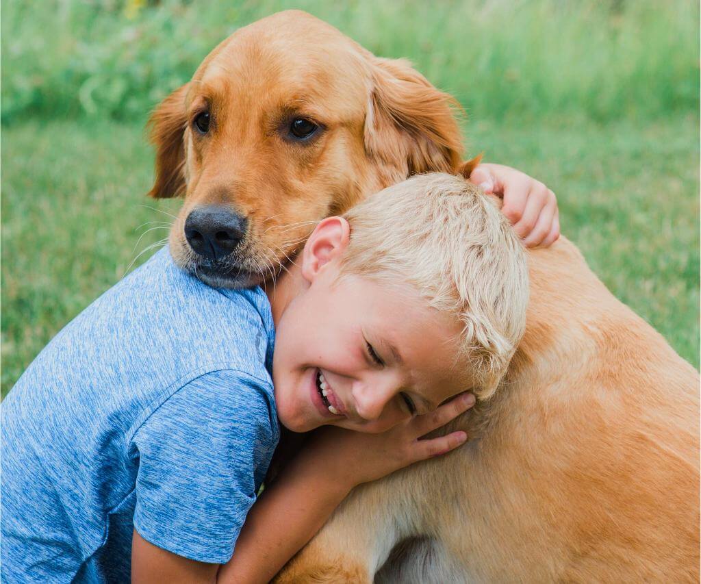 Young boy hugging his beloved dog in a touching moment recognizing the need to send the perfect dog memorial gifts